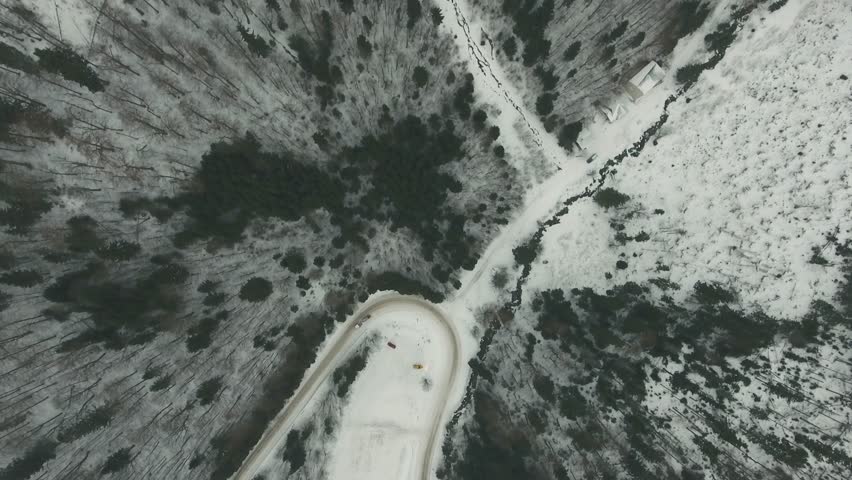 Aerial view of a cars driving on a slippery road in winter.