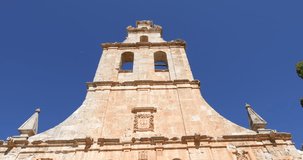 4k video. Tilt shot of landmark of facade, from belfry to sculpture of San Francisco de Asis, in ancient convent, from thirteenth century, in old town of Ayllon village, in Segovia, Spain, Europe
