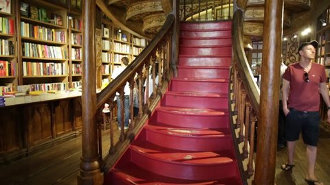 Oporto, Portugal - August 13, 2017: large wooden staircase with red steps inside Library Lello and Irmao in historic center of Porto, famous for Harry Potter film. Horizontal shot.