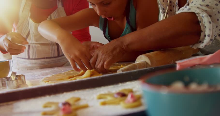 Happy multi-generation family preparing cookies in kitchen at home 4k Social distancing and self isolation in quarantine lockdown for Coronavirus Covid19 | Shutterstock HD Video #31476088