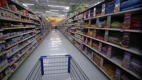 TAMPA, FLORIDA - AUGUST 2017: Shopping Inside Walmart -  Steadicam POV of Aisle with canned food, dry snacks, baking flour etc.