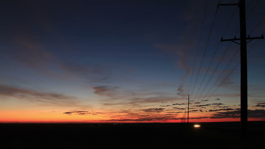 Golden Sunrise on the plains, with powerlines silhouette framing the scene. HD