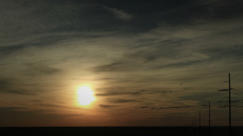 Thin clouds in front of the morning sun, with powerlines. Notice the iridescent ring around the sun. HD 1080p timelapse.