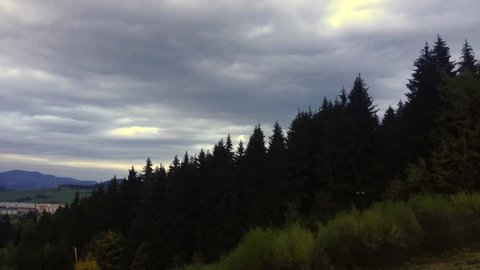 Time-lapse of clouds moving over autumn trees. Background autumn mountains
