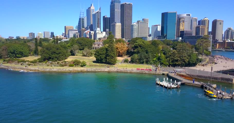 View of the Sydney Harbour with some ferries passing by Sydney Opera House in Sydney, Australia.