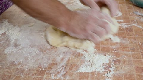 kneads the dough with his hands on the table hd