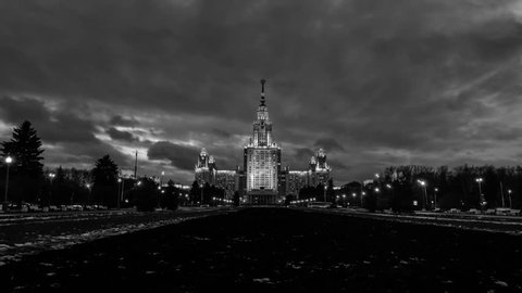 Time-lapse of illuminated Lomonosov Moscow State University at night. Popular landmark in Russia. Time-lapse with car trails and dark fast pacing sunset sky. Black and white