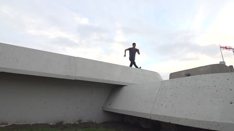 Pro Freerunner - does thred the needle front flip to wall flip on concrete terraced walls. Shot in Slow Motion