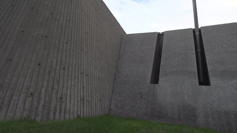 Professional parkour dare devil does crazy difficult 2 step wall flip off of architectural angled walls. Close Angle. Shot in Slow Motion