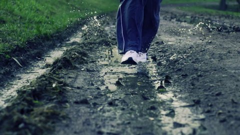 Jogger legs running through puddle, super slow motion, shot at 480fps
