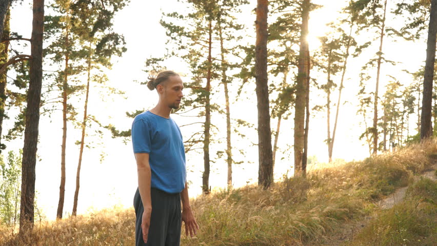 Happiness sportsman doing gymnastic exercise in the woods by the river
