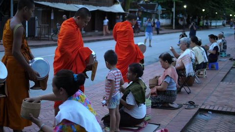 Buddhist Philanthropy Concept. Buddhist Monks Line Up in Row Waiting for Buddhism People to Give Alms Bowl in Thai Temple at Morning Time. Luang Prabang, Laos, 23 August, 2017. HD, 1920x1080. 