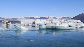 Amazing view of floating icebergs in the glacial lake Jokulsarlon on the background of clear blue sky, Iceland
