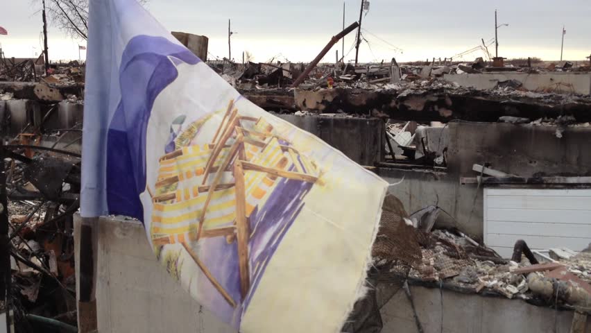 BREEZY POINT, QUEENS, NY - December 2, 2012: Video clip of wreckage and debris from fire from Hurricane Sandy.  A beach flag displays the sunny, laid back lifestyle of beach community and citizens.