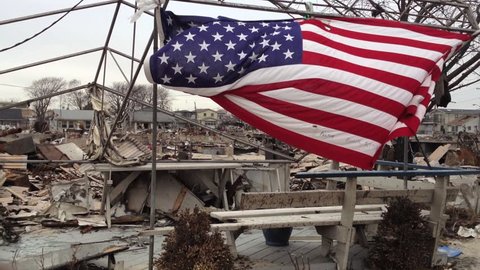 BREEZY POINT, QUEENS, NY-December 2, 2012: Video clip of wreckage and debris from homes destroyed by devastating fire during Hurricane Sandy.  Clip pans across wreckage, ends up on American flag.