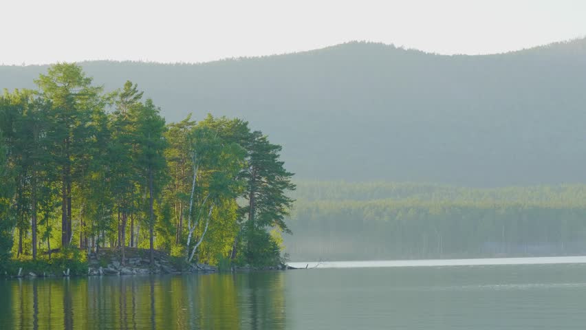 Beautiful blue clear water on the shore of the lake. View of the lake of the woods