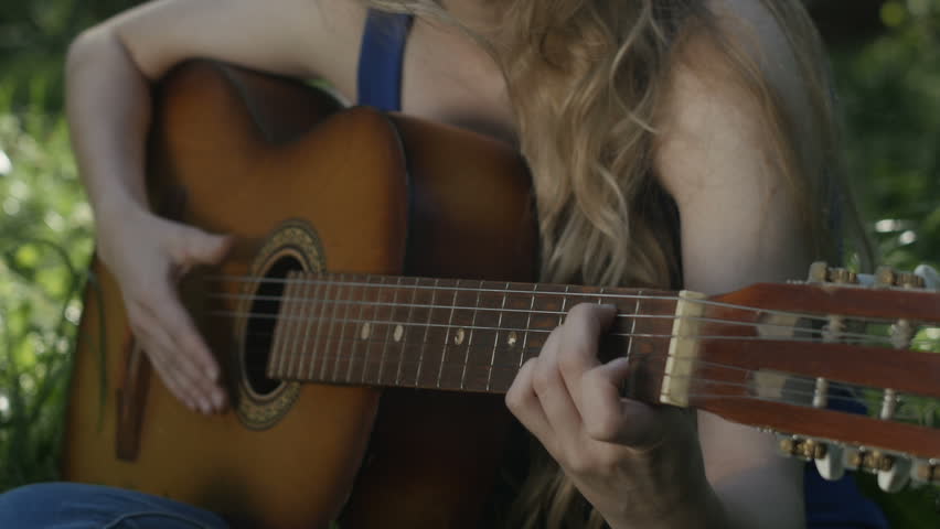 Hand of a girl playing a guitar close-up