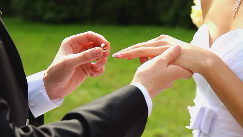 closeup of bride and groom exchanging wedding rings over green nature background Royalty-Free Stock Footage #3153232