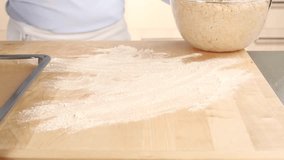Bread dough being shaped into a loaf on a floured work surface