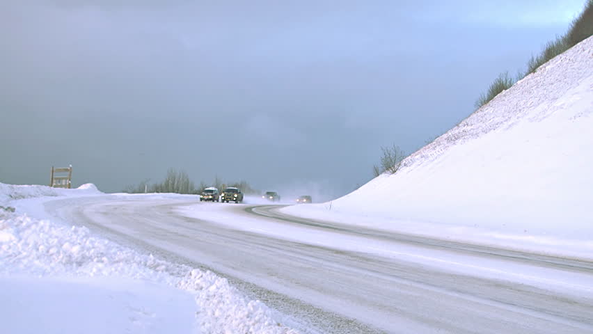 HOMER, AK - CIRCA 2012: Several vehicles being driven on a snowy Alaskan road in