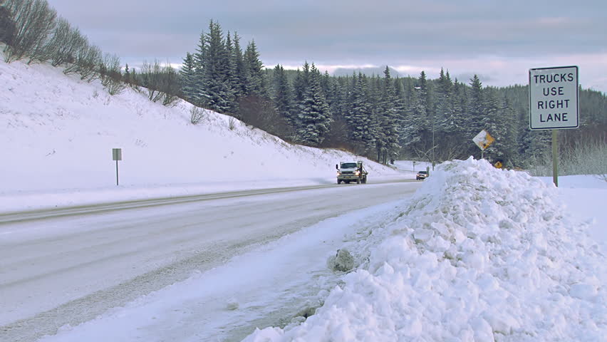 HOMER, AK - CIRCA 2012: Several vehicles being driven on a snowy Alaskan road in