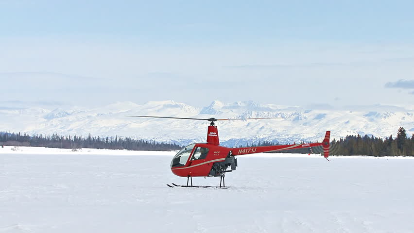 HOMER, AK - CIRCA 2012: Red 2-man helicopter (Robinson R22) with an instructor