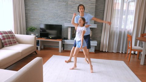 A happy family. Dad and daughter having fun in a clean house. A man is dancing with a vacuum cleaner.