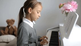 Cute little girl playing piano at home.