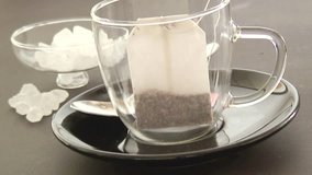 Hot water being poured over a fruit tea bag in a cup