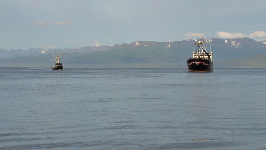 HOMER, AK - CIRCA 2011: A large crab boat and a fishing trawler move closer
