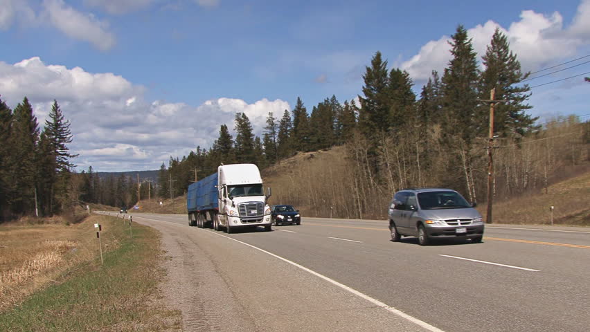 BRITISH COLUMBIA, CANADA - CIRCA 2012: Two tractor-trailer trucks pass by on the
