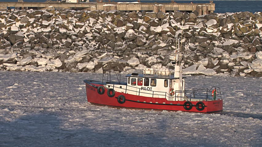HOMER, AK - CIRCA 2011: A red pilot boat returns to Homer Harbor dashes back