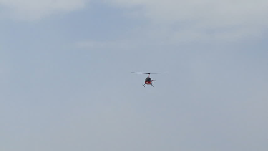 HOMER, AK - CIRCA 2012: Red 2-man helicopter (Robinson R22) flying above,
