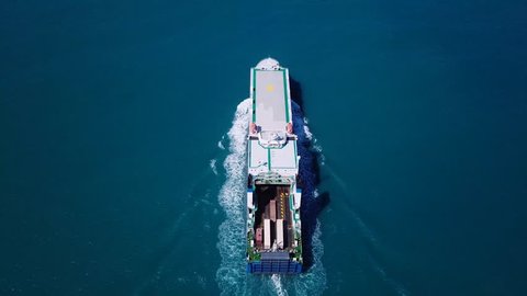 Aerial footage of a large Roro ship at sea. Roll-on/roll-off (RORO) ships are vessels designed to carry wheeled cargo, such as cars, trucks and railroad cars.