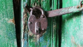Old vintage iron lock on the door with green paint peeled. with keys sticking out in it close up view - Powered by Shutterstock - Get 15% off with code: PIKWIZARD15
