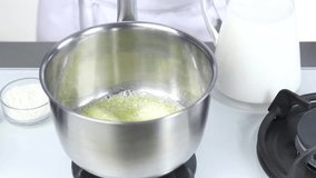 Flour being added to melted butter and milk being added