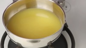 Cream cheese being added to gelatine in orange juice