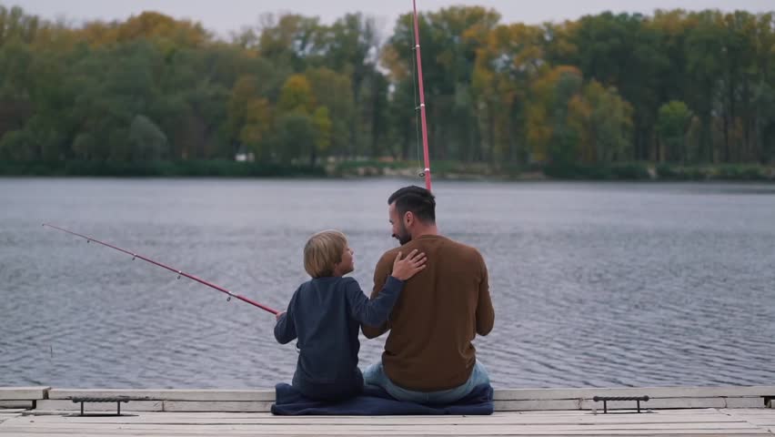 Dad encourages his son on fishing.