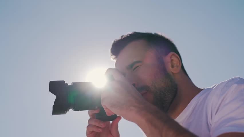 a man with beard takes a photo.