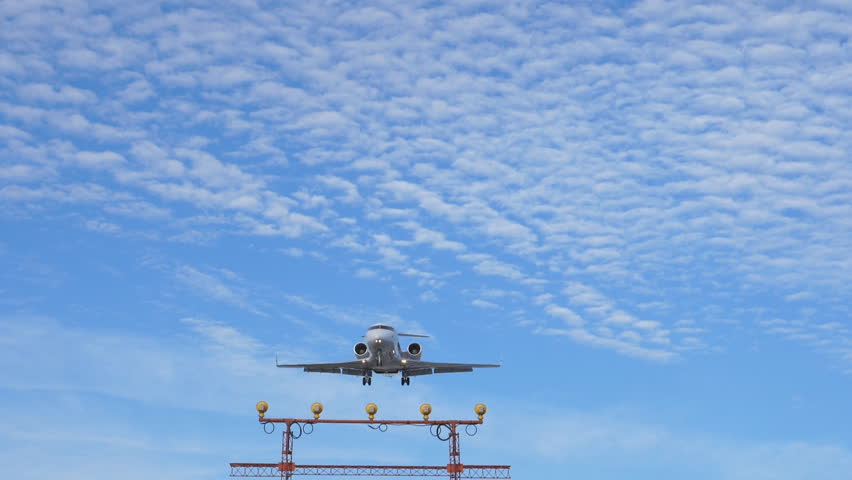 Slow motion shot. Small white private jet flies overhead on final approach and arrival at Pearson International Airport, Toronto, Ontario, Canada. No visible logos.
 Royalty-Free Stock Footage #31556146