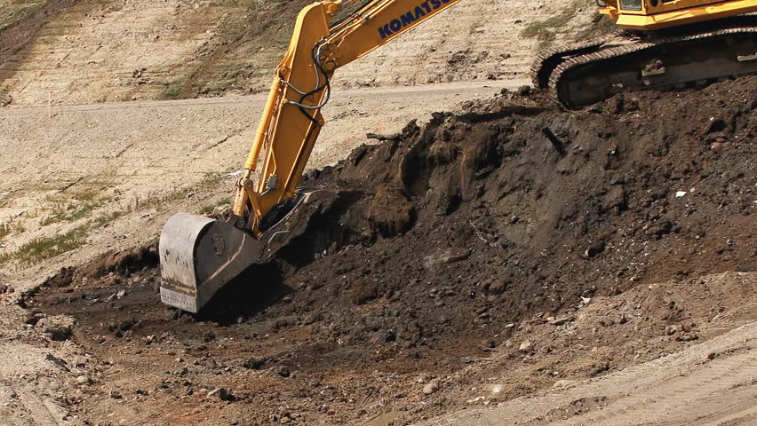HOMER, AK - CIRCA 2012: Excavator bucket scooping earth.