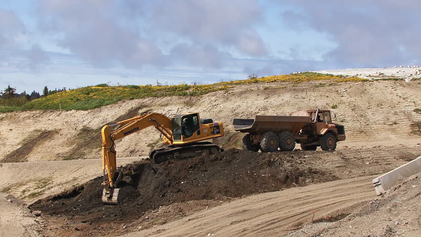 HOMER, AK - CIRCA 2012: Excavator scoops, swivels, and extends arm to dump