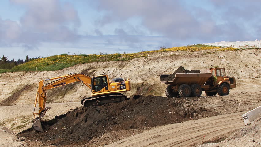 HOMER, AK - CIRCA 2012: Excavator and dump truck being operated as a team to
