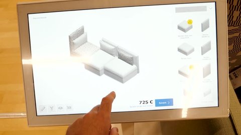 PARIS, FRANCE - CIRCA 2017: Virtual Reality furniture composition modular parts on touchscreen ikea shop - male had touching the VR screen select furniture parts, colors, garment, linen