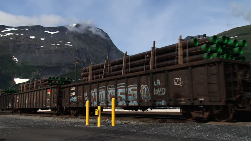 WHITTIER, AK - CIRCA 2012: Several heavily-laden railroad cars moving past in