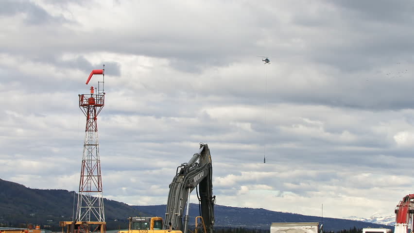 HOMER, AK - CIRCA 2012: Mid-sized helicopter with barrel sling suspended from a