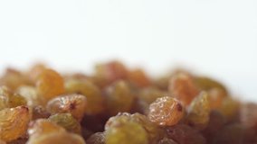 Golden dry raisins are rotating close up