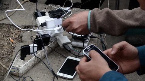 Refugees from Syria using mobile phones in camp to contact their families  