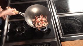 sauteing prawns with garlic, chilli and herbs in a wok
