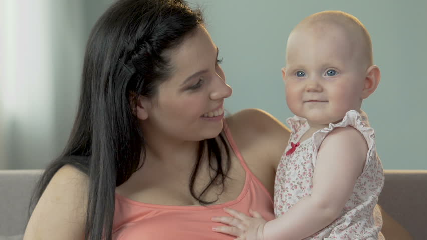 Young female holding and touching baby girl with nose, child hugging her, love | Shutterstock HD Video #31576081